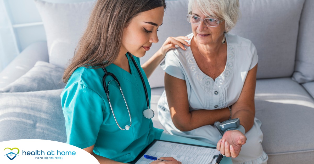 A nurse checks on the vitals of a senior patient at home, showing part of the home health monitoring process.