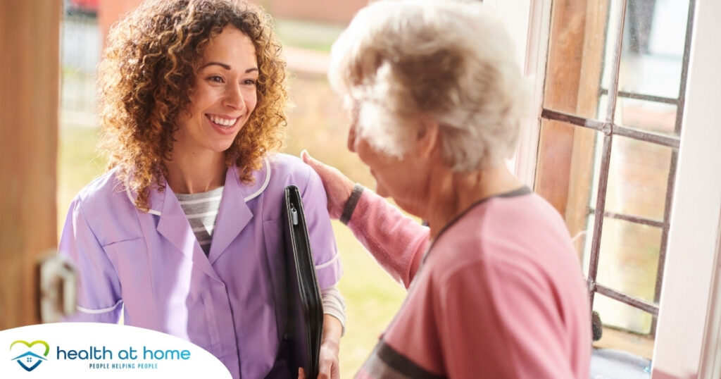 A happy caregiver enters the home of a client, representing in-home recovery care.