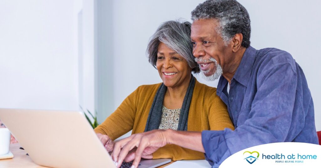 A senior couple looks at a computer, representing older adults looking for payment options for home health care.