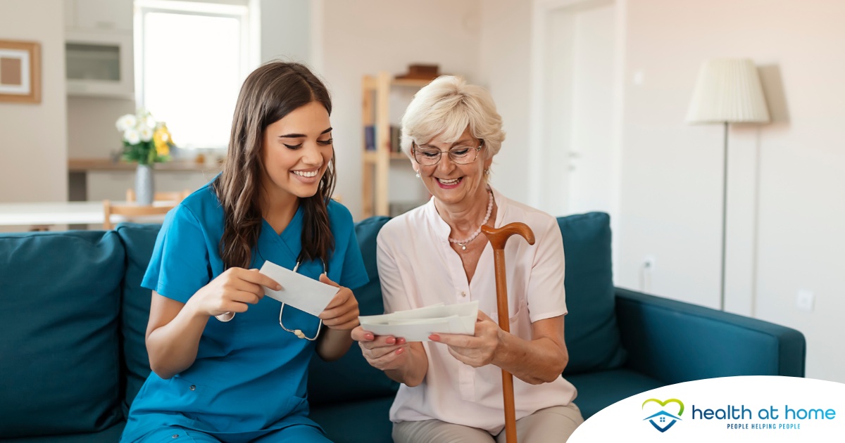 A caregiver reads cards with an older client, representing the fulfillment that comes with a career in home health care.