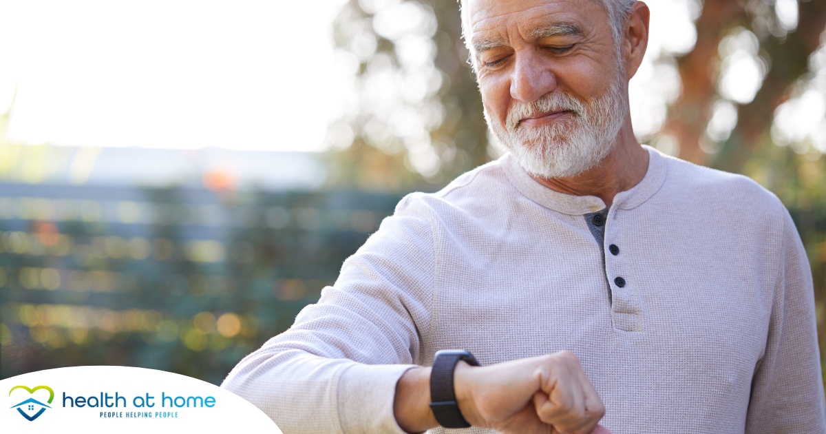 A senior man wears a smart watch, representing one of the many ways smart technology is shaping home health care.