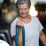 An older woman uses a resistance band to exercise, representing how staying active can help older adults keep their blood pressure in a healthy range.