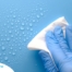 A gloved hand wipes down a surface, representing hygiene and practices that home health workers should employ.