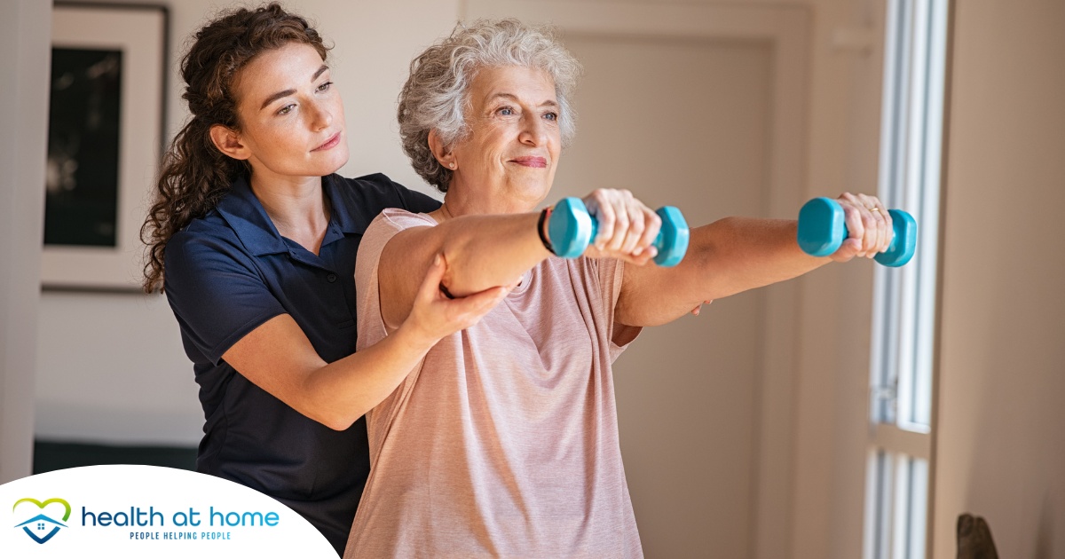 A physical therapist helps an older patient lift weights, representing how home health professionals can help with the hospital to home transition and the recovery that it entails.