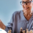 An older woman plays chess, an activity that can help older adults stay sharp.