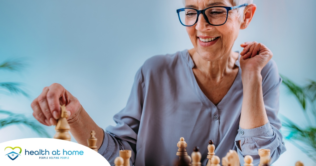 An older woman plays chess, an activity that can help older adults stay sharp.