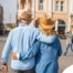 2 older adults hug while on vacation representing the successful outing that can still happen while caring for elderly loved ones.