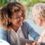 A caregiver warmly speaks with an older client, representing the quality communication that can come with bilingual care.