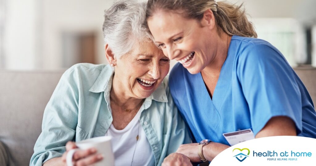 A caregiver laughs with a client representing how good social skills can help professional caregivers.