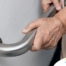 An older adult uses a grab bar representing one of the home modifications that is helpful for fall prevention for elderly adults.