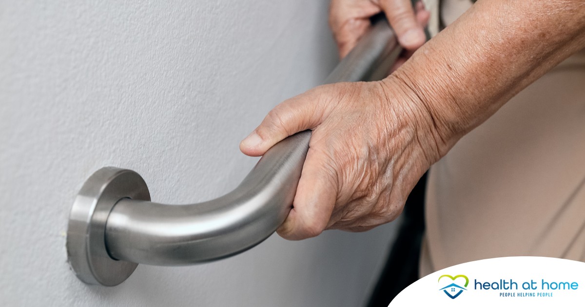 An older adult uses a grab bar representing one of the home modifications that is helpful for fall prevention for elderly adults.