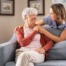 caregiver daughter and elderly mother on couch discussing private duty care