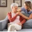 caregiver daughter and elderly mother on couch discussing private duty care