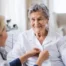 dementia at home care provider helping button client's shirt