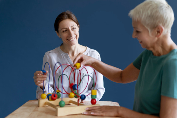 Therapist assisting senior with bead maze for cognitive health and Medicare.