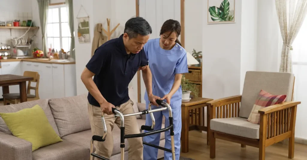 In-home care aide assists with home acre for stroke survivor with walker, supporting recovery.