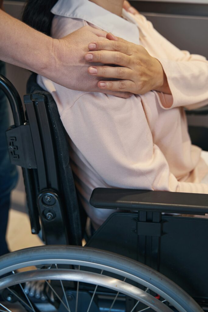 Caring hands comforting a person in a wheelchair, representing in-home care in Port Salerno.