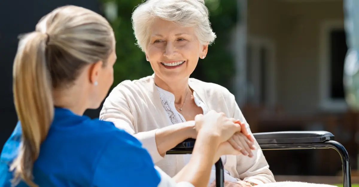Senior woman in wheelchair with caregiver in Florida home care setting.